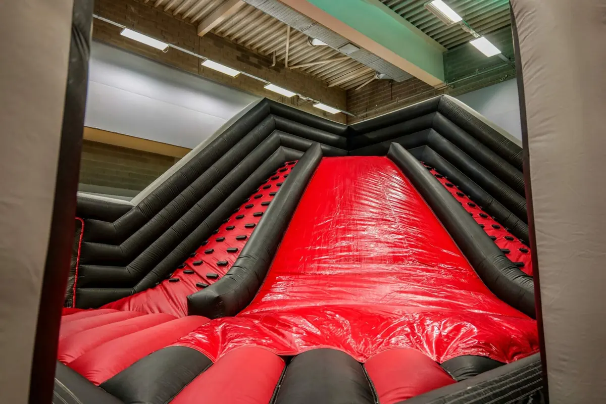 A red and black inflatable slide at the Dare2Air indoor inflatable theme park
