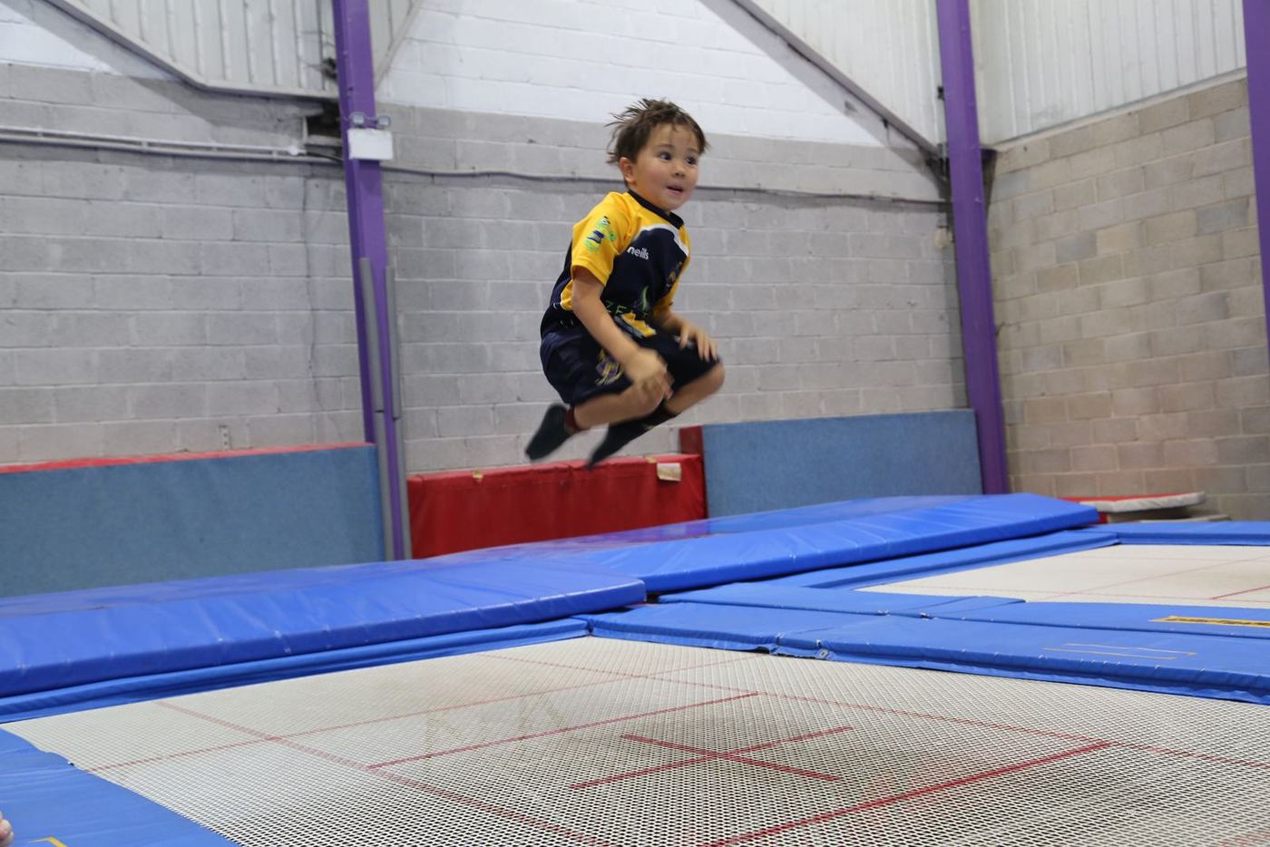 A boy jumping high on the trampoline