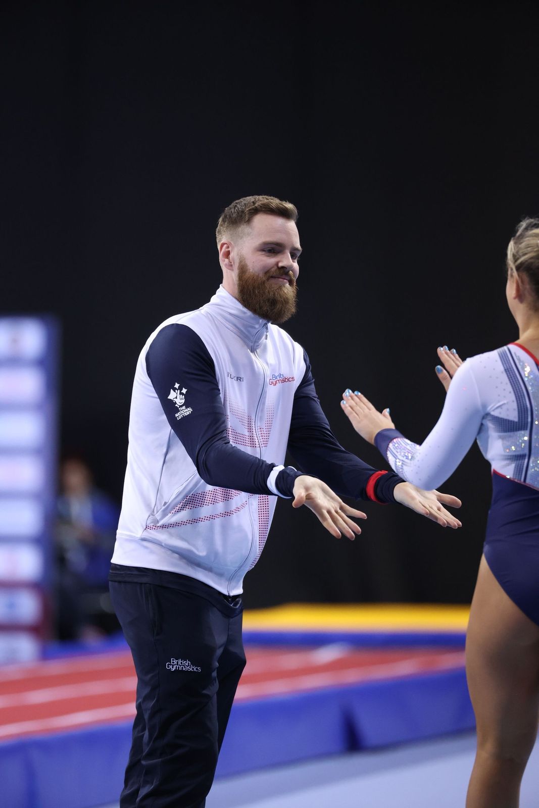 A coach high-fiving a KTGA gymnast at a competition