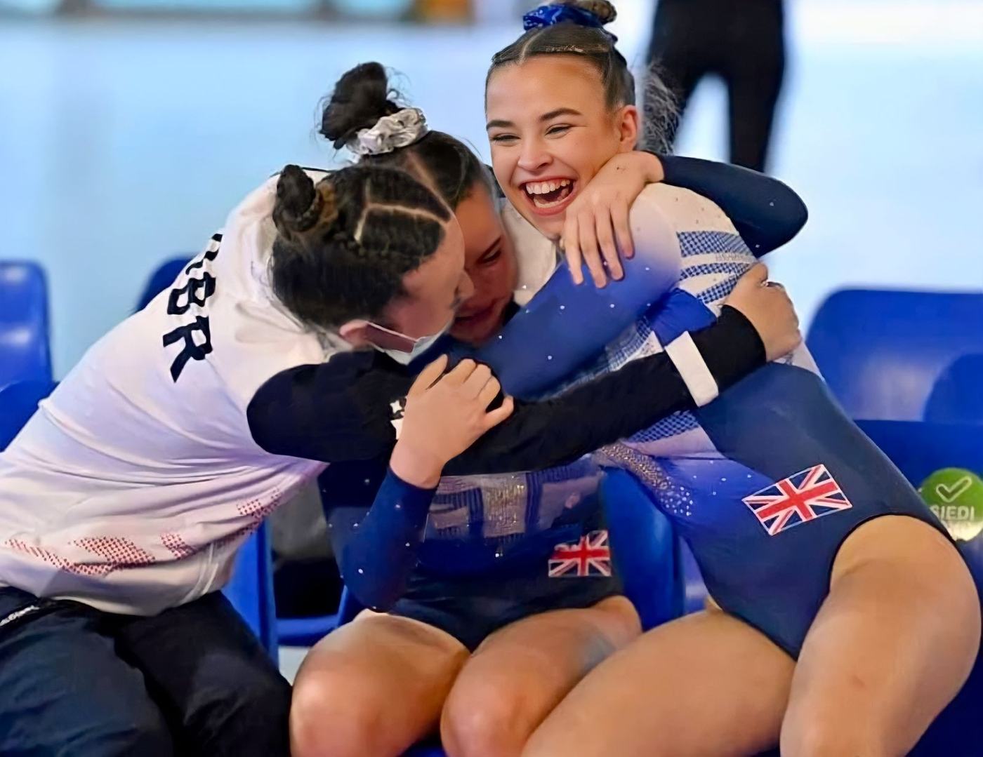 Great Britain gymnasts celebrating with a hug