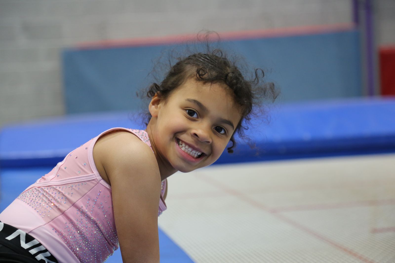 A smiling young gymnast on the trampoline at KTGA